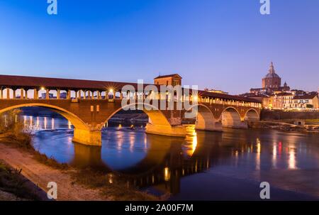 Pont Ponte Coperto lumineux donne sur la rivière Tessin avec cathédrale, crépuscule, Pavie, Lombardie, Italie Banque D'Images