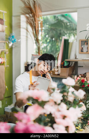 Les petites entreprises. Male florist bouquet faire au comptoir 24 dans le magasin de fleurs. L'homme assistant ou propriétaire en floral design studio, faire des décorations d'un Banque D'Images