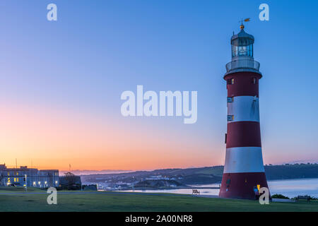 Plymouth, Devon, Angleterre. Jeudi 19 septembre 2019. Météo britannique. Après une autre nuit glaciale et claire, les premiers rayons de soleil apparaissent derrière Smeaton's Tower sur l'Hoe, l'éclairage dans le port de Plymouth, Devon, Angleterre du Sud-Ouest . Terry Mathews/Alamy Live News. Banque D'Images