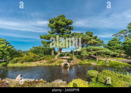 Kanazawa, Ishikawa, JAPON - 22 août 2018 : pins japonais et une lanterne de pierre (Ishidoro) à l'intérieur d'un étang de jardin Kenrokuen Banque D'Images