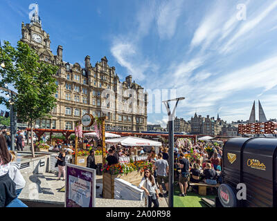 Entrée au village du festival en plein air de vente d'aliments et de boissons sur le dessus de la galerie marchande de Waverley à Princes Street Edinburgh Scotland UK avec Balmoral Hotel derrière Banque D'Images