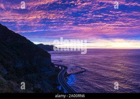 Sea Cliff Bridge sur le lever du soleil avec une belle rose et pourpre, ciel et l'océan shore sur l'arrière-plan. Le pont fait partie du Grand Pacific Highway Banque D'Images