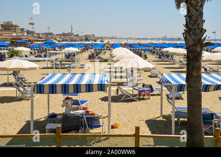 Portrait d'une plage de sable de la côte de la Versilia de Toscane avec parasols et chaises longues dans un jour d'été ensoleillé, Lido di Camaiore, Lucques, Italie Banque D'Images