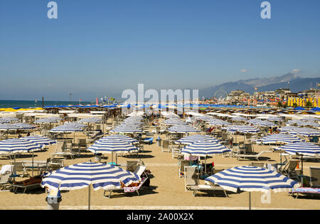 Portrait de la plage de sable de Lido di Camaiore avec rangées de parasols dans une journée ensoleillée, la Toscane, la Versilia, Italie Banque D'Images