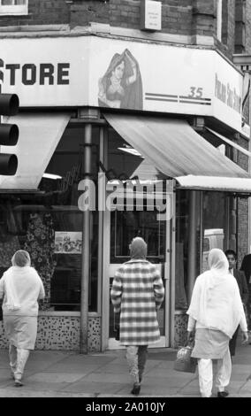 Southall, Londres 1972. Les femmes en robe indienne sur la rue principale. Après Idi Amin commandé 30 000 Asiatiques hors de l'Ouganda avec préavis de 90 jours, ceux avec un passeport britannique dirigé vers l'Angleterre. Ils ont été forcés de quitter leurs fonds, leurs biens et possessions derrière. Ces images documentent la vie de certaines des personnes lorsqu'ils se sont installés dans la région de Southall, à l'ouest de Londres. Un aperçu de la vie il y a 47 ans pour les immigrés au Royaume-Uni. Photo par Tony Henshaw Banque D'Images