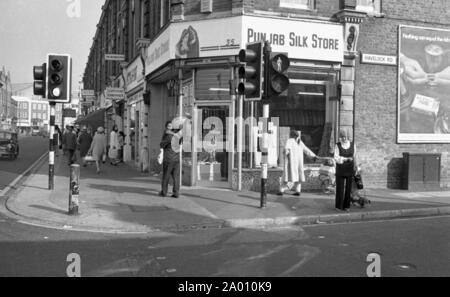 Southall, Londres 1972. Scène de rue haute à la jonction avec Havelock Road, Southall, avec des peuples asiatiques et des boutiques. Après Idi Amin commandé 30 000 Asiatiques hors de l'Ouganda avec préavis de 90 jours, ceux avec un passeport britannique dirigé vers l'Angleterre. Ils ont été forcés de quitter leurs fonds, leurs biens et possessions derrière. Ces images documentent la vie de certaines des personnes lorsqu'ils se sont installés dans la région de Southall, à l'ouest de Londres. Un aperçu de la vie il y a 47 ans pour les immigrés au Royaume-Uni. Photo par Tony Henshaw Banque D'Images