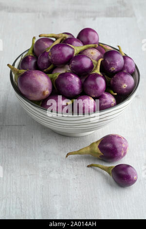 Bol avec des matières premières fraîches mini aubergines violet comme casse-croûte Banque D'Images