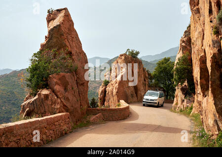 Route étroite et tortueuse de conduite par la rose rouge et les granite rock côte du golfe de Porto en Corse France. Banque D'Images