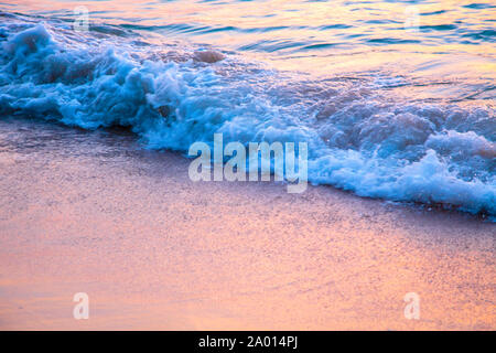 Coucher du soleil sur la mer. plage de sable fin, l'eau claire. vague sur un fond coucher de soleil. Banque D'Images