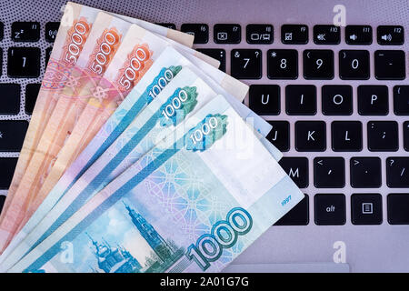 Un paquet de roubles russes se trouve sur le clavier d'ordinateur portable. Vue d'en haut. Banque D'Images