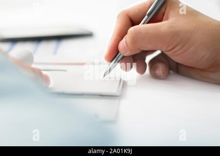 Photo de l'Homme documents de travail avec un stylo. Isolé sur un fond blanc. Banque D'Images