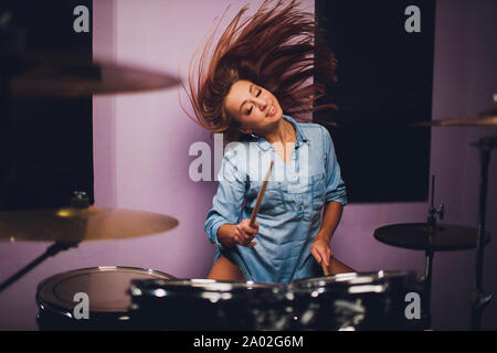 Photographie d'un batteur de femmes jouant un ensemble de batterie sur scène. Banque D'Images