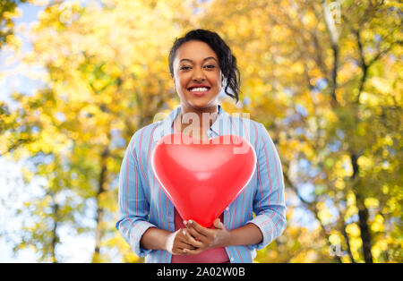 African American Woman with heart-shaped balloon Banque D'Images