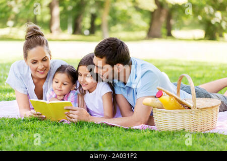 Livre de lecture en famille pique-nique sur le parc en été Banque D'Images