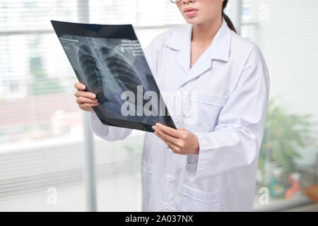 Confident female doctor examining précisément une cage thoracique x-ray Banque D'Images