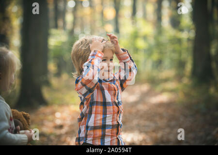 Deux petits enfants smiling cute marcher ensemble dans le parc aux beaux jours d'automne. L'amitié entre frères et soeurs. Concept de famille heureuse Banque D'Images