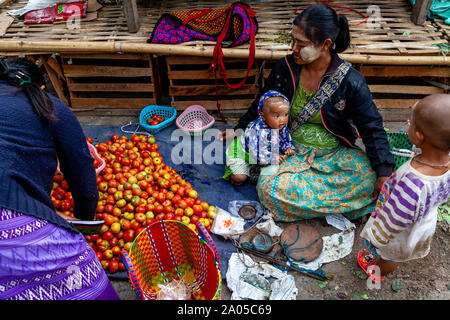 Une mère birmane et les enfants la vente de tomates à l'Mingalar, marché Nyaung Shwe, le lac Inle, l'État de Shan, Myanmar. Banque D'Images