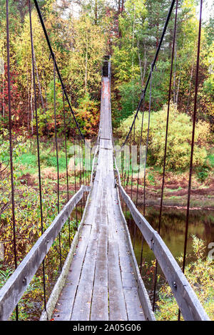 La suspension fait main en bois ancien pont suspendu sur la rivière sur un parc naturel automne fond. Soft focus sélectif. Copie du texte de l'espace. Pont automne chute Banque D'Images