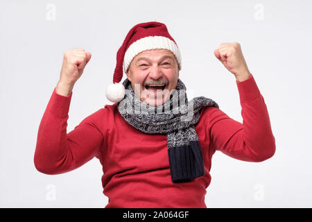 Mature joyeux noël hispanic man in hat est heureux avec des cadeaux et crier wow. Les mains en l'heureux de présenter. Studio shot Banque D'Images