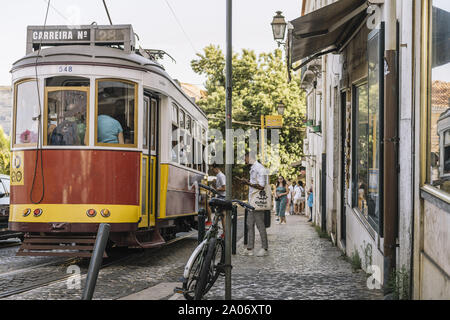 Lisbonne, Portugal - août 2019 : tramway touristique pleine de gens dans une rue pavée d'Alfama Banque D'Images