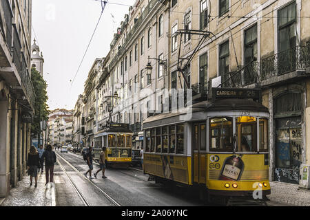 Lisbonne, Portugal - août 2019 : jaune touristique de trams et de personnes dans une rue typique du quartier de Baixa au crépuscule Banque D'Images