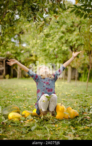 Heureux belle enfant mains dans jardin d'automne Banque D'Images