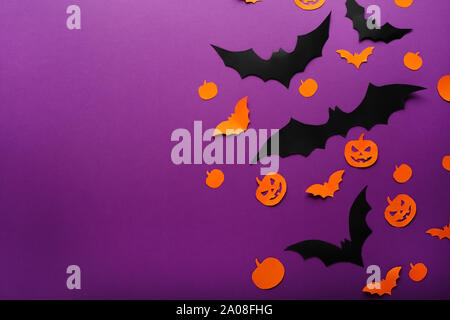 Fond d'Halloween avec des citrouilles en papier, Jack O'Lantern, noir, orange papier chauves-souris volant au-dessus de fond violet, . Copier l'espace. Et l'Halloween Banque D'Images