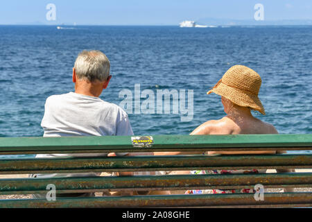 SORRENTO, ITALIE - AOÛT 2019 : l'homme et la femme assise sur un banc sur le front de mer de Sorrente face à la mer. Banque D'Images