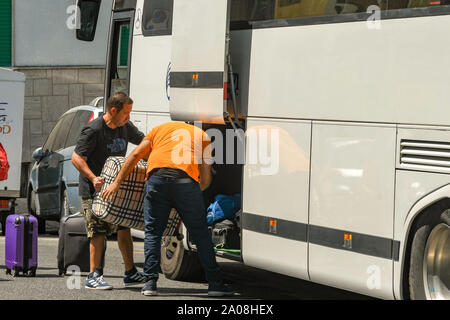 NAPLES , ITALIE - AOÛT 2019 : charger des bagages dans la soute d'un bus de tournée à Sorrento. Banque D'Images