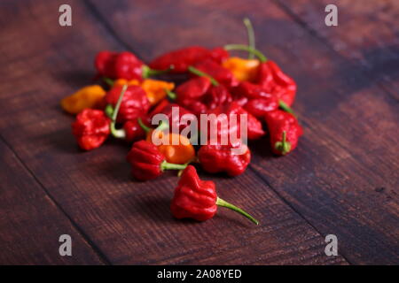 Bunch of red chili peppers on wooden table Banque D'Images