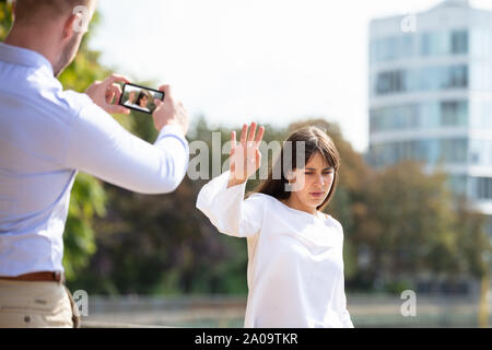 Jeune Femme Homme refusant de prendre Photo de Son sur téléphone mobile Banque D'Images