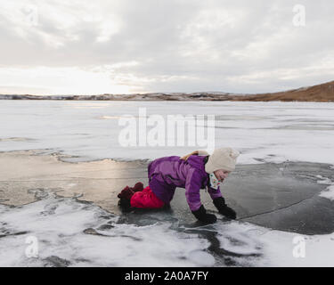 Petite fille joue sur lac gelé Banque D'Images