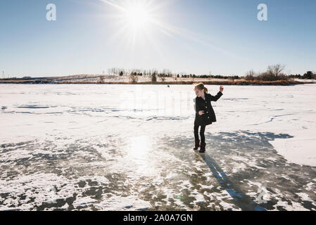 Petite fille joue sur lac gelé Banque D'Images