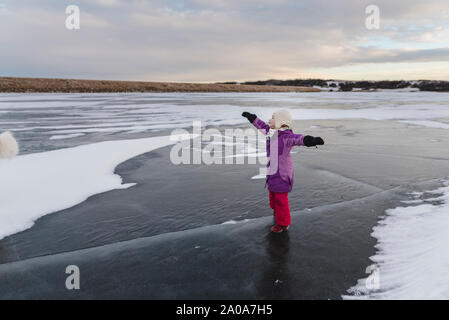 Petite fille joue sur lac gelé Banque D'Images