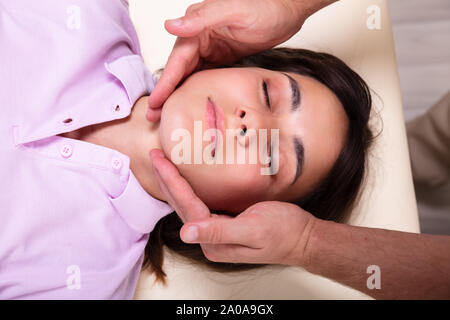 Close-up of a Young Woman Receiving Relaxant Massage à partir de la mâchoire d'une clinique de physiothérapie Banque D'Images