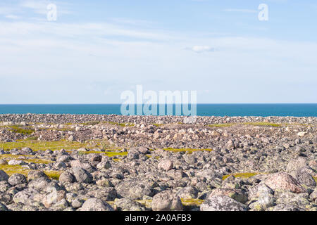 Rocky seashore. D'énormes rochers arrondis sur la plage. La mer de Barents brille avec toutes les nuances de bleu en été. Parmi les pierres peuvent être vus à o Banque D'Images