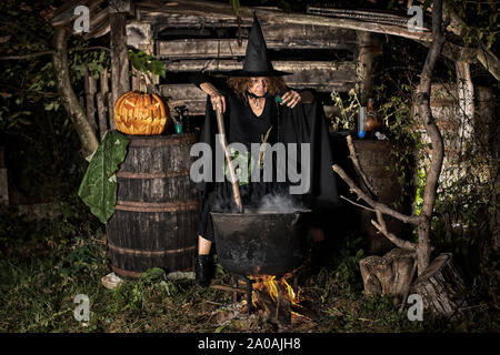 Vieille sorcière potion mortelle de brassage pour l'Halloween dans un pot en fonte Banque D'Images