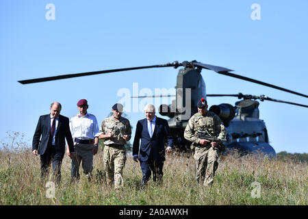 Premier ministre Boris Johnson, avec le secrétaire à la défense, Ben Wallace, arrive dans un hélicoptère Chinook pour visiter le personnel militaire sur la plaine de Salisbury zone formation près de Salisbury. Banque D'Images