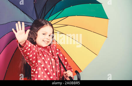 Petite fille en imperméable. automne fashion hipster joyeux. enfant dans l'humeur positive. protection contre la pluie. Arc-en-ciel. Heureux petite fille avec parapluie colorés. Belle désinvolture. Banque D'Images