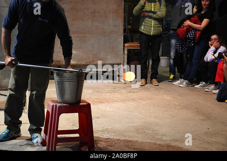 Souffleur de verre formant, en tournant le verre chauffé dans une belle, du verre décoratif cheval dans un atelier sur l'île de Murano, Venise, Italie Banque D'Images