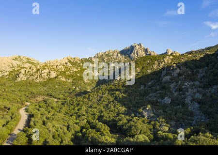 Vue de dessus, superbe vue aérienne de certaines montagnes de granit avec une route qui les traverse. Sardaigne, Italie. Banque D'Images