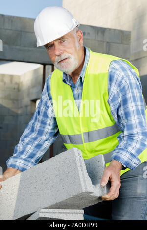 Un travailleur masculin tenant à l'extérieur de ciment Banque D'Images