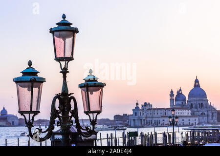 Italie Venise ville au coucher du soleil sur gondola polonais à la cathédrale Santa Maria della Salute canal plus allumé la lampe en verre de Murano Banque D'Images