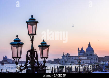 Italie Venise ville au coucher du soleil sur gondola polonais à la cathédrale Santa Maria della Salute canal plus allumé la lampe en verre de Murano Banque D'Images