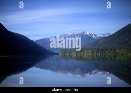 Une montagne aux conifères, vert et bleu ciel reflétant à Birkenhead Lake comme dans un miroir, sur l'eau calme, dans un endroit isolé de la Colombie-Britannique destination Banque D'Images