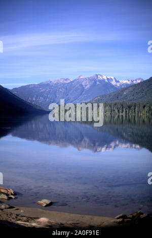 Une montagne aux conifères, vert et bleu ciel reflétant à Birkenhead Lake comme dans un miroir, sur l'eau calme, dans un endroit isolé de la Colombie-Britannique destination Banque D'Images