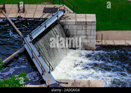L'eau coule sur le bord d'un verrou dans un canal. Escaliers et murs en pierre les verrous de ligne, qui sont entourées d'un parc public. Banque D'Images