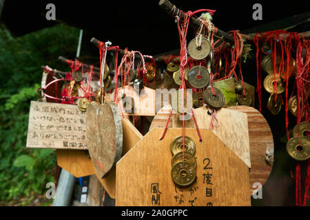 EMA (plaques de prière japonaises en bois shinto) accroché à des pièces de 5 yens, dans un sanctuaire dédié au succès dans les relations. Banque D'Images