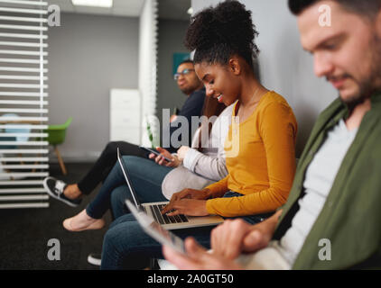 Concentrés smiling young african american woman en attente d'embauche se préparer à parler in office Banque D'Images