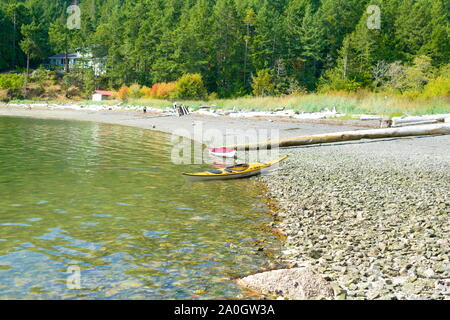 Un kayak jaune sur la plage de Medicine Beach à North Pender Island, Colombie-Britannique, Canada Banque D'Images